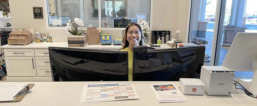 Smiling female at the front desk at Heritage clubhouse.